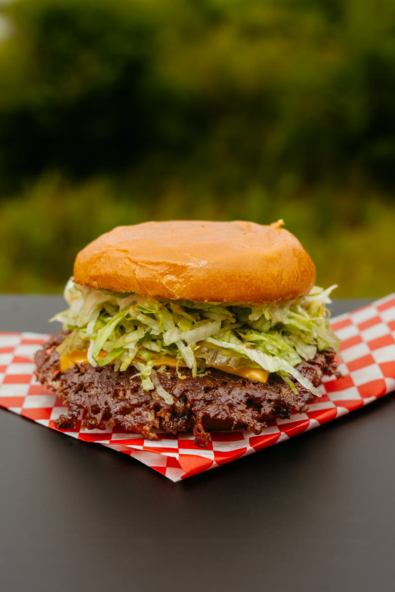 THE MACnificent — smash patties with double American cheese, pickles, iceberg, griddled onions on a toasted brioche bun